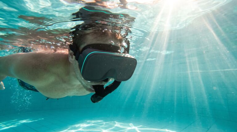 Swimmer wearing a snorkel and waterproof underwater VR headset floating in a sunlit pool