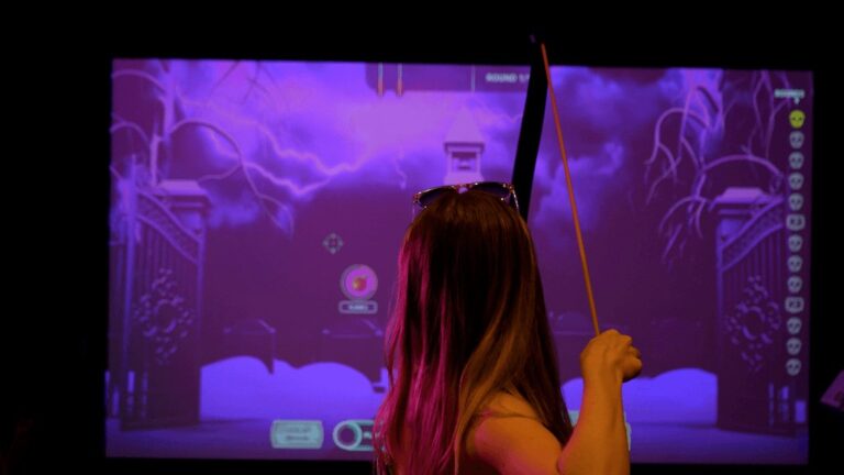 A player draws a real bow at a projected Virtual Archery target screen. Photo: 501 FUN