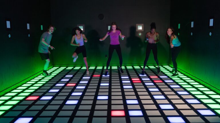Players jumping across the light-up floor tiles of Activate's Mega Grid game room. Photo: Activate