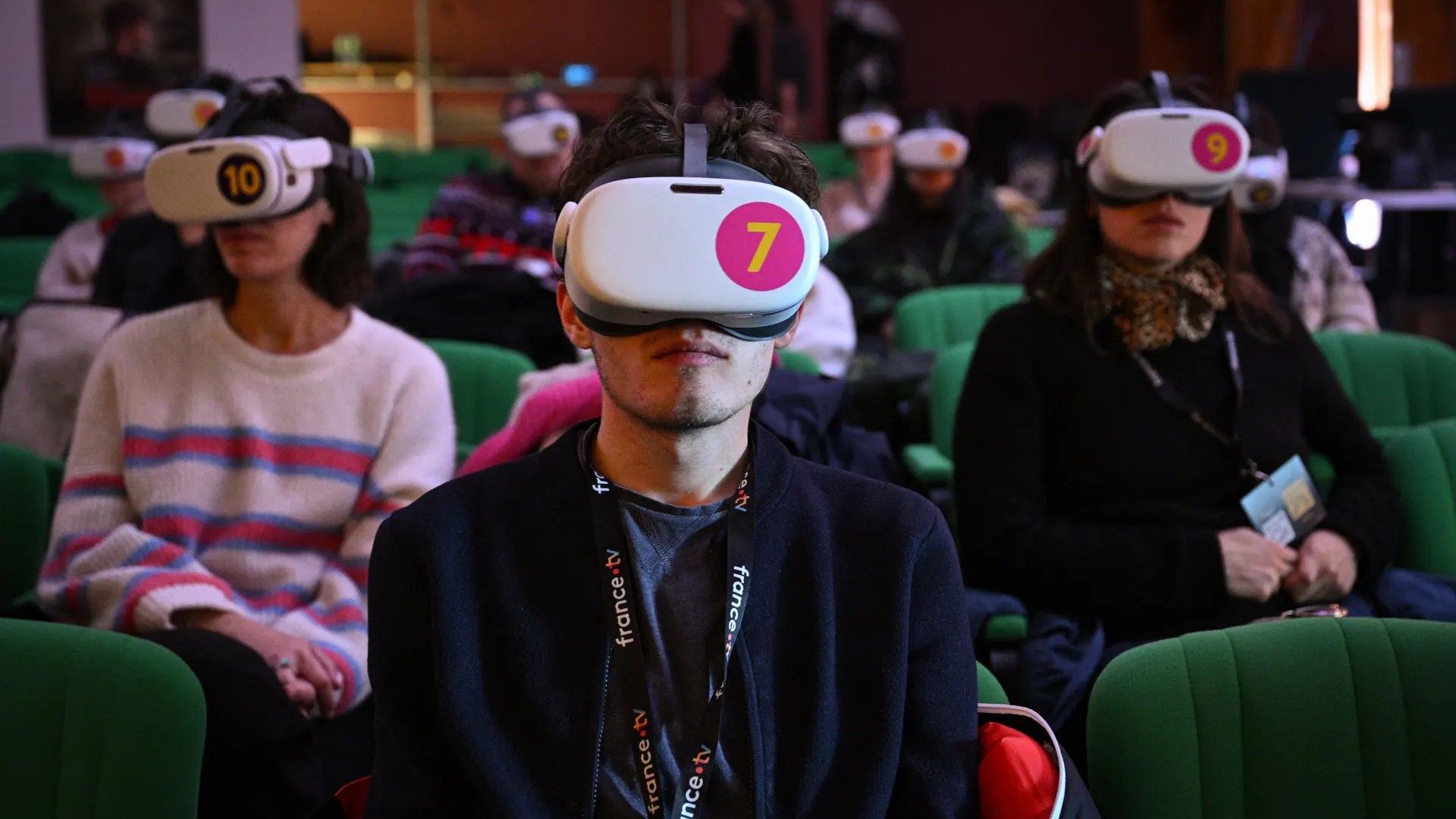 Viewers wearing numbered VR headsets during a seated 360-degree session in a cinema auditorium at the Les Arcs Film Festival. Photo: Claire Nicol / Traverse