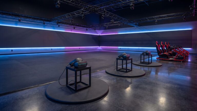 A free-roam VR arena with personal VR stations and motion racing simulators inside a VR entertainment destination